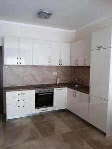 a kitchen with white cabinets and a sink and a refrigerator at Melodia del Mare 2 in Kotor
