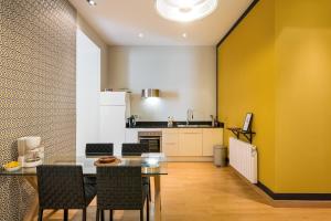 cocina y comedor con mesa y sillas en Honorê - Suites Bellecour, en Lyon