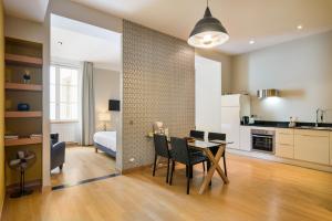 cocina y sala de estar con mesa y sillas en Honorê - Suites Bellecour, en Lyon