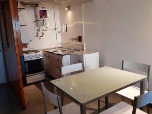 a kitchen with a white table and a table and chairs at Departamento Loft VCP in Villa Carlos Paz