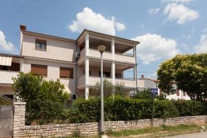 a white house with a stone wall and a street light at Apartments and Rooms Lorena 236 in Rovinj