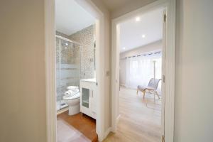 Baño blanco con aseo y silla en Apartamento Centro-Nautico, en Gijón