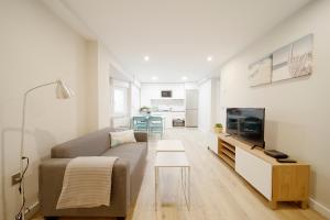 sala de estar con sofá y TV en Apartamento Centro-Nautico, en Gijón