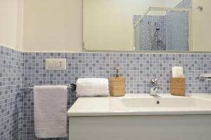 La salle de bains est pourvue d'un lavabo blanc et de carrelage bleu. dans l'établissement Blue Sea Villas by Wonderful Italy, à Ostuni 23 autres photos