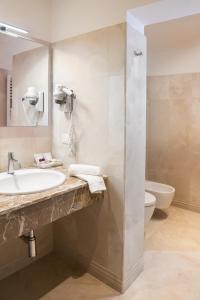 uma casa de banho com um lavatório, um WC e um espelho. em Hotel Agli Alboretti em Veneza