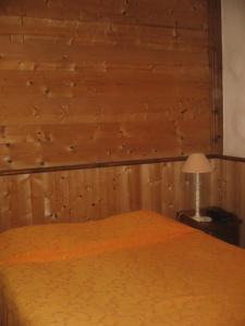 a bedroom with a bed with a wooden wall at Le Relais de l'Abbaye in Tournus