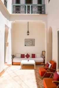 uma sala de estar com um sofá e uma mesa em Riad Dar Aicha en Exclusivité em Marrakech