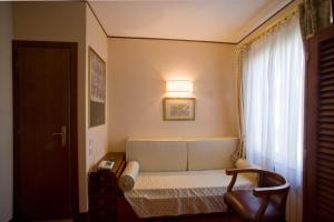 a small bedroom with a bed and a window at Hotel Agli Alboretti in Venice