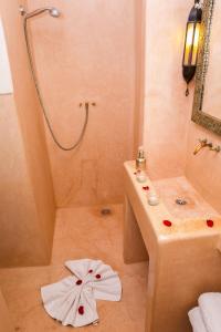 a bathroom with a shower and a towel on the floor at Riad Dar Aicha en Exclusivité in Marrakesh