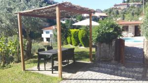 a table under an umbrella in a garden at Chalé da Fonte - T2 in Geres