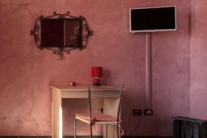 una camera con tavolo, sedia e televisore di Mary's House a Civitavecchia