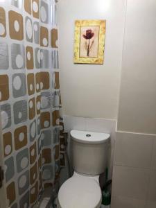 a bathroom with a toilet and a picture on the wall at Centropolis in Manila