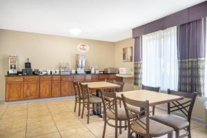 a kitchen and dining room with tables and chairs at Super 8 by Wyndham Harrison OH in Harrison