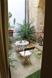 a patio with a table and chairs and plants at Buon Consiglio B&B in Lecce