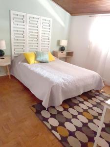 um quarto com uma cama com duas mesas e uma janela em Casa70 em Setúbal