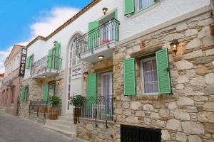 a group of buildings with green shutters on them at Brothers Cesme Hotel in Cesme