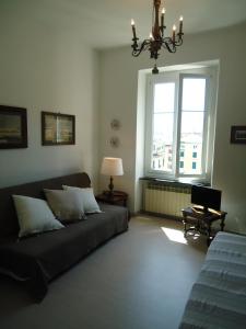 een woonkamer met een bank en een raam bij The terrace, my place in Genua