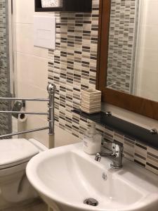 a bathroom with a sink and a toilet and a mirror at B&B Mariupol in Trapani