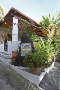 ein Gebäude mit einem Lichthaus mit Pflanzen und einem Schild in der Unterkunft Pedra Residence in Stromboli