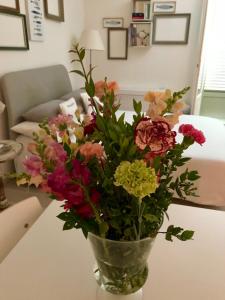 un jarrón lleno de flores en una mesa en Studio Chateau - Vieux Nice, en Niza