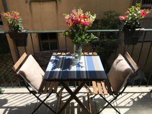 una mesa y dos sillas con un jarrón de flores en Studio Chateau - Vieux Nice, en Niza