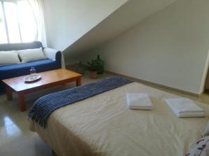 サンルーカル・デ・バラメダにあるCasa Algaidaのベッドルーム(ベッド1台、青いソファ付)
