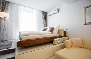 1 dormitorio con cama, sofá y ventana en Above the historical roofs, en Bratislava