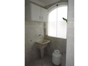 a bathroom with a sink and a toilet at Condomínio Baia Blanca in Guarujá