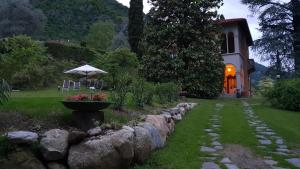 una casa con un camino de piedra junto a una casa con sombrilla en Villa Ucci Luxury B&B, en Onno