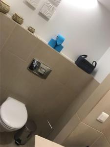 uma casa de banho com um WC branco e tecidos azuis em Apartamento TT Ocean - Herdade dos Salgados na Guia