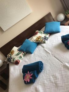 białe łóżko z niebieskimi poduszkami w obiekcie Apartamento TT Ocean - Herdade dos Salgados w mieście Guia