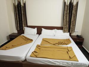 a bedroom with a bed with white sheets and gold blankets at Sapphire stay in Bangalore