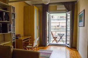 ein Wohnzimmer mit einer Tür, die auf einen Balkon führt in der Unterkunft An apartment for 2-4 friends. in Thessaloniki