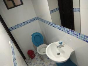 bagno con servizi igienici blu e lavandino di Hotel Royal Center a Pasto