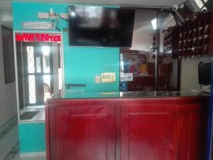 a red counter in a store with a tv on the wall at Hotel Royal Center in Pasto