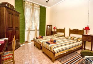 - 2 lits dans une chambre aux murs verts dans l'établissement Domo Silvia E Paolo, à Nuoro