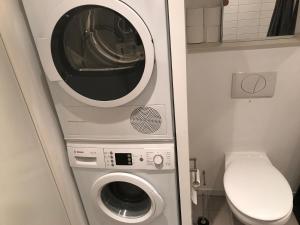 a washer and dryer in a small bathroom at Home Stay Marmormolen (Marmorvej) in Copenhagen