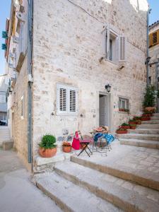 a stone building with a table and chairs in front of it at Successus Old Town House in Hvar