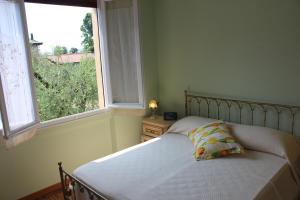 een bed met een kussen in een slaapkamer met een raam bij Brezza di Lago in Salò