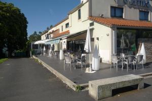 un restaurante con sillas, mesas y sombrillas en una acera en PENSIÓN RESTAURANTE "O RETIRO ", en Arzúa