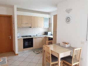 a kitchen with a wooden table and a table and chairs at Appartamento Marina in Arco