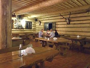 a group of people sitting at wooden tables in a room at Chata z bali Bukowina in Wetlina