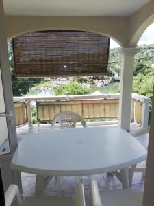 a white table and chairs on a porch with a window at Villa Acajou sur Mer in Rodrigues Island
