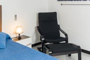カディスにあるCoqueto estudioのベッドの横の部屋に座る黒い椅子