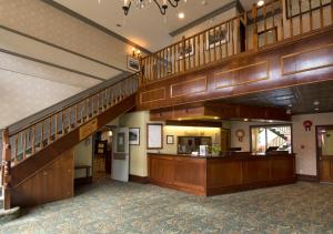 een grote lobby met houten vloeren en houten trappen bij Westmark Inn Dawson City in Dawson City