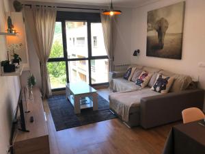 soggiorno con divano e dipinto con un elefante di Apartamento Ezcaray con Piscina a Zorraquín