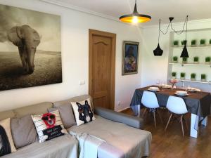 una sala de estar con sofá, mesa y una pintura de elefante en Apartamento Ezcaray con Piscina, en Zorraquín