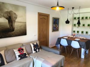 un soggiorno con un divano, un tavolo e un dipinto di un elefante di Apartamento Ezcaray con Piscina a Zorraquín