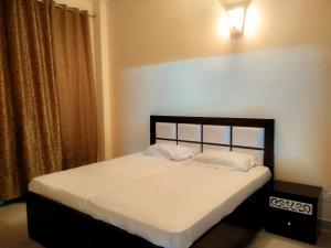 a bedroom with a bed with white sheets and a window at The Desire Hostel in New Delhi