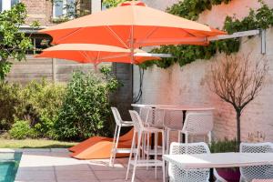 una mesa y sillas con una sombrilla en el patio en B&B Koto, en Amberes